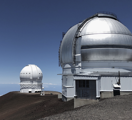dwa białe budynki obserwatorium położone na szczycie góry